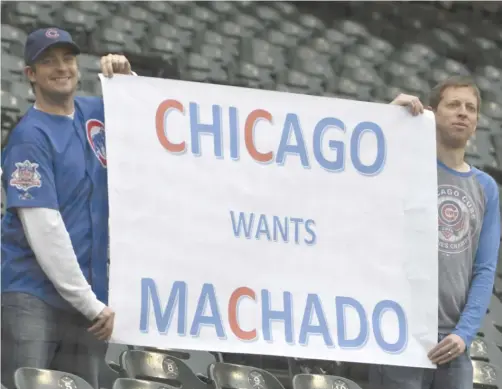  ?? DAVID BANKS/ GETTY IMAGES ?? Two Cubs fans share the prevailing sentiment about Machado during the Sox game. The Orioles are expected to trade him this summer.