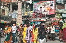  ?? NIHARIKA KULKARNI / AFP ?? People walk past a hoarding of the Bharatiya Janata Party along the roadside in Varanasi, India, on Saturday.