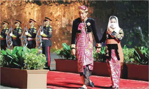  ?? — AFP ?? Indonesian President Joko Widodo and his wife Iriana Widodo review the honour guard at the welcoming dinner during the G20 Summit in Badung on the Indonesian resort island of Bali on Tuesday.