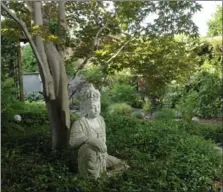  ??  ?? A tranquil Buddha in the garden.