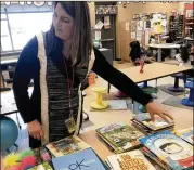  ?? JERRY DAVICH/POST-TRIBUNE ?? Tina DeBrock, a kindergart­en teacher at Protsman Elementary School in Dyer, Ind., looks through some of the donated books on mental health wellness.