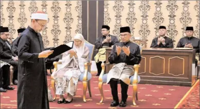  ?? -AFP ?? KUALA LUMPUR
Malaysia’s newly appointed Prime Minister Anwar Ibrahim (C-R) and his wife Wan Azizah Wan Ismail (C-L) take part in the swearing-in ceremony at the National Palace