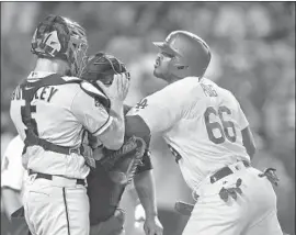  ?? Allen J. Schaben Los Angeles Times ?? IN THE OFTENTIMES heated tradition of Dodgers-Giants games, Yasiel Puig shoves San Francisco catcher Nick Hundley in the seventh inning. Both players were ejected. “If they suspend me, I think they have to suspend him,” Puig says.