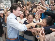  ?? CP PHOTO ADRIAN WYLD ?? Canadian Prime Minister Justin Trudeau shakes hands with people as he walks through the lobby of a building in downtown Manila, Philippine­s Monday November 13.