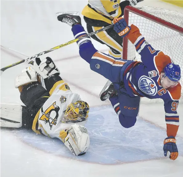  ?? ED KAISER ?? Oilers captain Connor McDavid goes airborne over Penguins goalie Marc-Andre Fleury during Friday night’s game at Rogers Place.