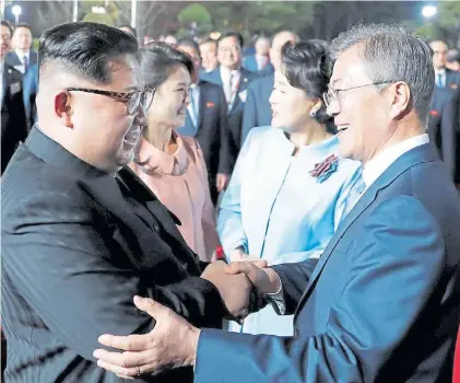  ?? AFP ?? Gestos. Afinidad y buena onda entre los líderes. Atrás la esposa del surcoreano y la hermana de Kim.