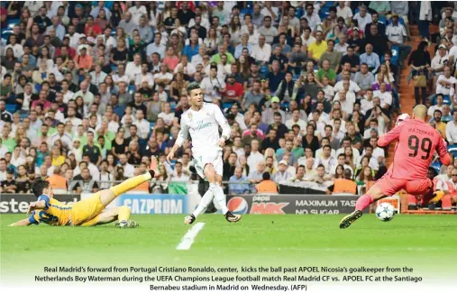  ??  ?? Real Madrid’s forward from Portugal Cristiano Ronaldo, center, kicks the ball past APOEL Nicosia’s goalkeeper from the Netherland­s Boy Waterman during the UEFA Champions League football match Real Madrid CF vs. APOEL FC at the Santiago Bernabeu stadium...