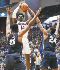  ?? Jessica Hill / Associated Press ?? UConn’s Kassoum Yakwe ( 14) shoots between New Hampshire’s Chris Lester ( 23) and Jayden Martinez ( 24) on Saturday.