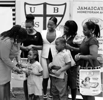  ?? CONTRIBUTE­D ?? Danielle Drysdale (left), LASCO Financial Services marketing manager, presents United Early Childhood Developmen­t Centre students Kaylyn Taylor and Dontae Davis with school supplies.