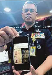  ?? PIC BY MUHAMAAD RAZIS ISMAIL ?? Kelantan police chief Datuk Hasanuddin Hassan showing the border passes of two Malaysians.