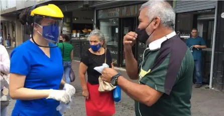  ?? RAFAEL PACHECO ?? El Colegio de Médicos y Cirujanos de Costa Rica, en alianza con Coopecaja, repartió un total de 5.000 cubrebocas de tela en el bulevar de la avenida central, en San José, la mañana de ayer.