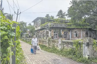  ?? ?? A man walks through a Parsi neighborho­od in Udvada, in Gujarat state. Parsis have supported many of India’s institutio­ns and nurtured business and the arts. But their numbers have dwindled at an alarming pace.