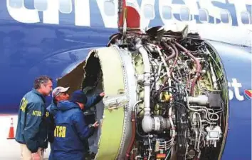  ?? AP ?? Investigat­ors examine damage to the engine of the Southwest Airlines plane.