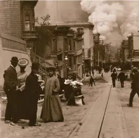  ?? Arnold Genthe / Fine Arts Museums of San Francisco 1906 ?? A group of Black residents stands on Clay Street west of Stockton Street after the 1906 earthquake as flames advance that would soon engulf their homes.