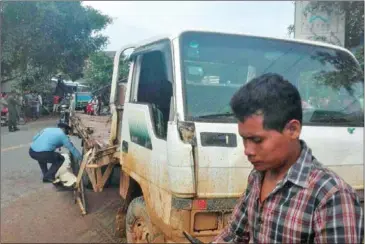  ?? PHOTO SUPPLIED ?? A police officer (left) inspects a truck in Svay Rieng yesterday morning after it was involved in a road collision, injuring 73 garment workers.