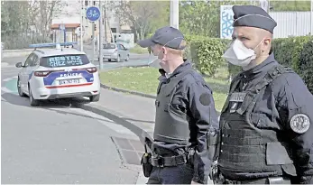  ?? — AFP photo ?? French police officers wearing a protective mask, control vehicles next to the message ‘stay home’ written on their police car in Marseille.