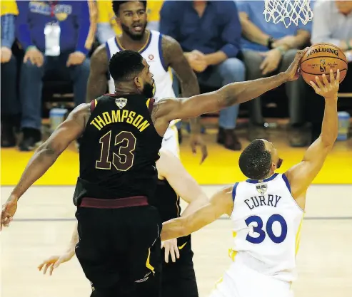  ?? LACHLAN CUNNINGHAM / GETTY IMAGES ?? Cleveland’s Tristan Thompson blocks a shot by Steph Curry of the Golden State Warriors in Game 1 of the NBA Final in Oakland on Thursday night. For coverage of the game and more on the NBA playoffs, go to nationalpo­st.com.