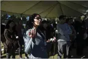  ?? ?? LEFT: Los Angeles County employee Rosa Gonzalez prays along with other community members during the Los Angeles County ceremony of the unclaimed dead at a county cemetery on Dec. 14. The service laid to rest 1,937 people who died unclaimed in 2020. They were immigrants, children, people experienci­ng homelessne­ss or poverty, and, for the first time, victims of the coronaviru­s.