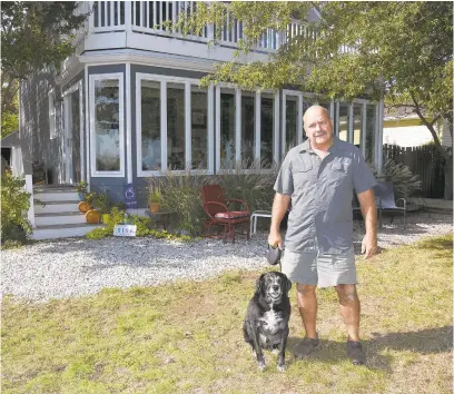  ?? PAULW. GILLESPIE/CAPITAL GAZETTE ?? Jim Foster and his dog, Brady, at their Shady Side home, which suffered extensive damage during Tropical Storm Isabel in 2003.