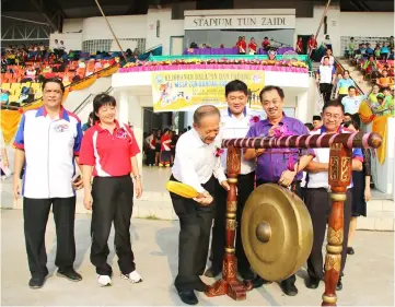  ??  ?? Tiong hitting a gong to start the inter-school sports meet. Looking on are Siok Hie (second left) and Chiong Hui (third left).