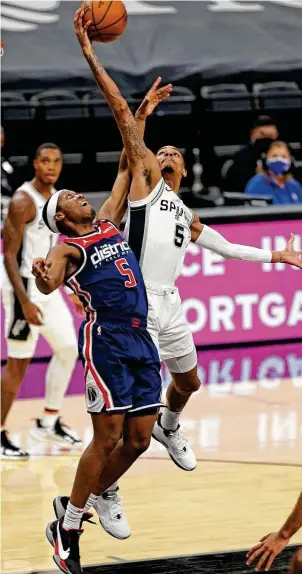  ?? Ronald Cortes / Contributo­r ?? Dejounte Murray, grabbing a rebound against Washington, on Sunday became the first Spur to post multiple triple-doubles in the same season since David Robinson had four in 1993-94.