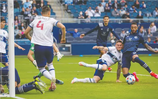  ?? WILLIAM PURNELL/USA TODAY SPORTS ?? Players from Sporting Kansas City and the Vancouver Whitecaps scramble for a loose ball in front of the goal during the second half of the MLS matchup. Kansas City dominated the game, handing Vancouver their second-straight loss with a 3-0 decision.