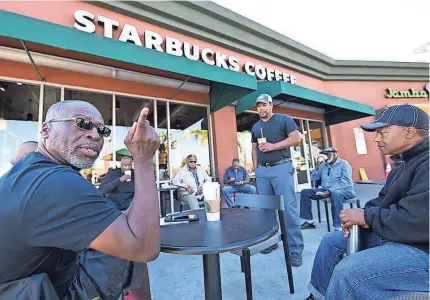  ??  ?? Fred Jackson, left, and Troy Huey chat at the Ladera Heights Starbucks, which has become a community gathering spot.