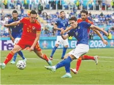  ?? ANDREAS SOLARO/POOL VIA REUTERS ?? Italy's Federico Chiesa fires a shot in front Wales' Connor Roberts during their Euro 2020 match in Rome.