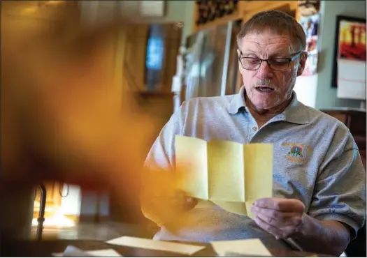  ?? (AP/Gillette News Record/Mike Moore) ?? U.S. Army veteran Dave Olsen looks Nov. 5 at a letter he wrote to his family while serving in the Vietnam War at his home in Gillette, Wyo.