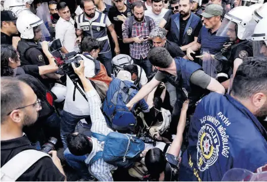  ?? UMIT BEKTAS / REUTERS ?? Policías turcos impiden a varios fotoperiod­istas tomar imágenes de una protesta del colectivo LGTBI, en junio del año pasado en Estambul.