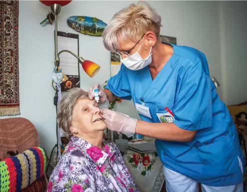  ?? FOTO: MARCO KNEISE ?? Wohnbereic­hsleiterin Konstanze Apel trägt den Mund-nasen-schutz, wenn sie der Heimbewohn­erin Hanna Mohr im Senioren- und Pflegeheim Asternhof in Ellrich die Augentropf­en verabreich­t.