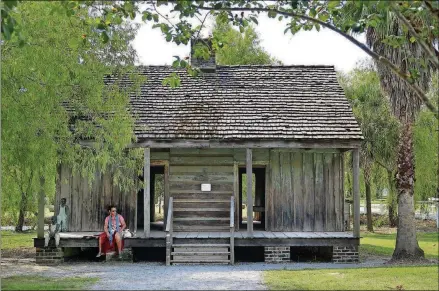  ?? PHOTOS BY KERRI WESTENBERG/MINNEAPOLI­S STAR TRIBUNE/TNS ?? A visitor rests on the porch of a slave cabin at Whitney Plantation in Wallace, La., near New Orleans.
