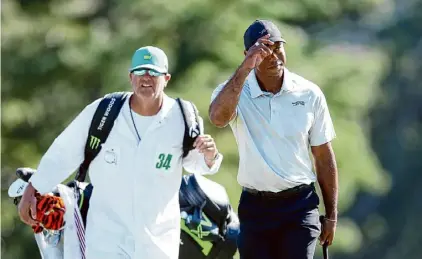  ?? Andrew Redington/Getty Images ?? Tiger Woods acknowledg­es the crowd while walking to the 18th green during the third round of the Masters at Augusta National Golf Club on Saturday in Augusta, Ga.