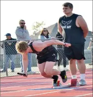  ?? TIMES photograph by Annette Beard ?? Sophomore runner Cade Mann takes off from the starting block held securely by Blackhawk Brandt Bowen.