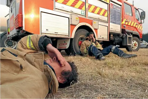  ?? MARTIN DE RUYTER/STUFF ?? Takaka volunteer firefighte­rs Callum Reid, front, and Grant Lawrence show the fatigue of fighting the out-of-control fire.