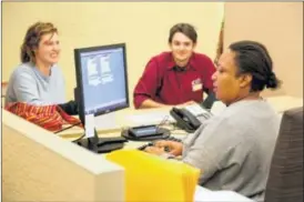  ?? LISA POWELL / STAFF ?? Deputy clerk Lisa Williams (right) issues a marriage license to Hannah Berry and Joshua Skidmore of Kettering on Thursday. Montgomery County’s Probate Court has added a third station to issue marriage licenses in preparatio­n for an influx of people who...