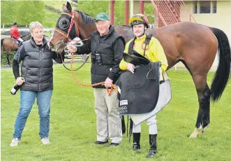  ?? PHOTO: LINDA ROBERTSON ?? Smart operator . . . Ownertrain­ers Nikki and Barrie Blatch and jockey Jacob Lowry celebrate with race 2 winner Mr Intelligen­ce at Wingatui yesterday.