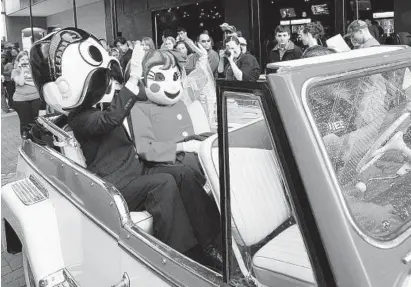  ?? KIM HAIRSTON/BALTIMORE SUN ?? Performers dressed as Salie Utz and Natty Boh wave to onlookers after a “wedding” was held at Power Plant Live to kick off a 2011 advertisin­g campaign by Smyth Jewelers.
