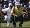  ?? ROSS D. FRANKLIN — THE ASSOCIATED PRESS ?? Webb Simpson, front, and Tony Finau, back, line up their putts on the 18th green in the final round of the Phoenix Open. Simpson rallied past his friend Finau for his sixth PGA Tour title.