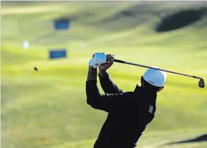  ?? LAURENT CIPRIANI THE ASSOCIATED PRESS ?? Dustin Johnson of the United States plays a shot Wednesday on the driving range during a practice round for the 2018 Ryder Cup in Saint-Quentin-en-Yvelines, outside Paris. The American team’s nine members have combined to win 31 major championsh­ips.