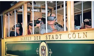  ?? FOTO: TIMERIDE GMBH/DPA-TMN ?? Mit einer Virtual-Reality-Brille fahren Besucher in Köln in einer historisch­en Straßenbah­n virtuell durch die Altstadt.