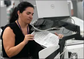  ?? (File Photo/AP/Lynne Sladky) ?? A worker organizes vote-by-mail ballots for scanning Nov. 8 during the midterm election at the Miami-Dade County Elections Department in Miami. Stories circulatin­g online incorrectl­y claim Florida’s ability to report election results quickly during the 2022 midterms means states that have taken longer, such as Arizona and Nevada, are engaged in fraud.