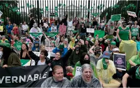  ?? AP ?? Abortion-rights demonstrat­ors shout slogans after tying green flags to the fence of the White House during a protest in Washington.