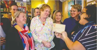  ?? ERROL MCGIHON ?? Ola Cocina owner Donna Chevrier receives a fundraisin­g check for $22,000 from some of her many supporters. Her business was broken into and vandalized earlier this week. The outpouring of support from the community has allowed her to reopen the business.