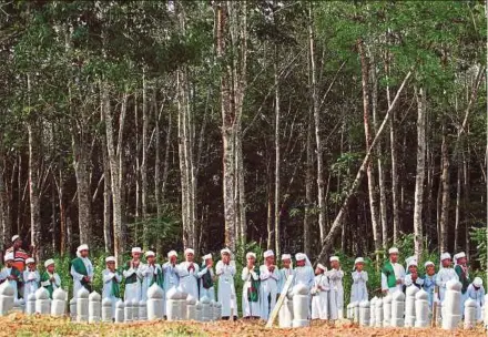  ?? FILE PIC ?? Rohingya religious school pupils reciting a prayer on the second anniversar­y of the Wang Kelian tragedy at a cemetery in Jalan Tualang, Pokok Sena, Kedah, in May.