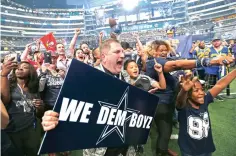  ?? Jae S. Lee/The Dallas Morning News via AP ?? ■ Dallas Cowboys fans, including Terry Cox who holds a sign, cheer when the Cowboys select Bo Scarbrough in the seventh round Saturday at the NFL football draft in Arlington, Texas.