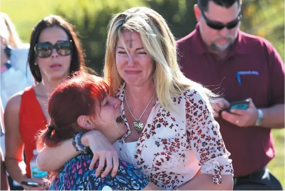  ?? AP PHOTO ?? Distraught parents wait for news after a shooting at Marjory Stoneman Douglas High School in Parkland, Fla., on Wednesday.