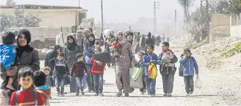  ?? AFP ?? Syrian civilians flee through the regime-controlled corridor opened by government forces in Hawsh al-Ashaari on the outskirts of Damascus on Thursday.