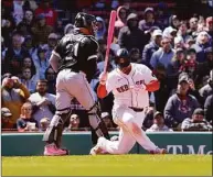  ?? Mary Schwalm / Associated Press ?? The Red Sox’s Rafael Devers spins as he strikes out while White Sox catcher Reese McGuire looks on during the eighth inning Sunday in Boston.