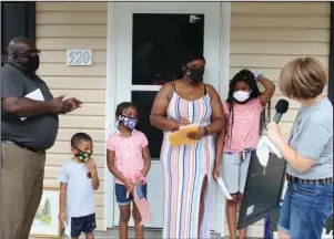  ?? The Sentinel-Record/Tanner Newton ?? HOME DEDICATION: The Hampton family, including Bobbie Hampton, left, Malik, Sa’Brina, Ashley Hampton and Ta’Kayla, are presented with a painting from Cindy Wagstaff that was donated to the family for their new Habitat for Humanity home at 520 Linwood Ave. during a dedication ceremony on Saturday, July 11.